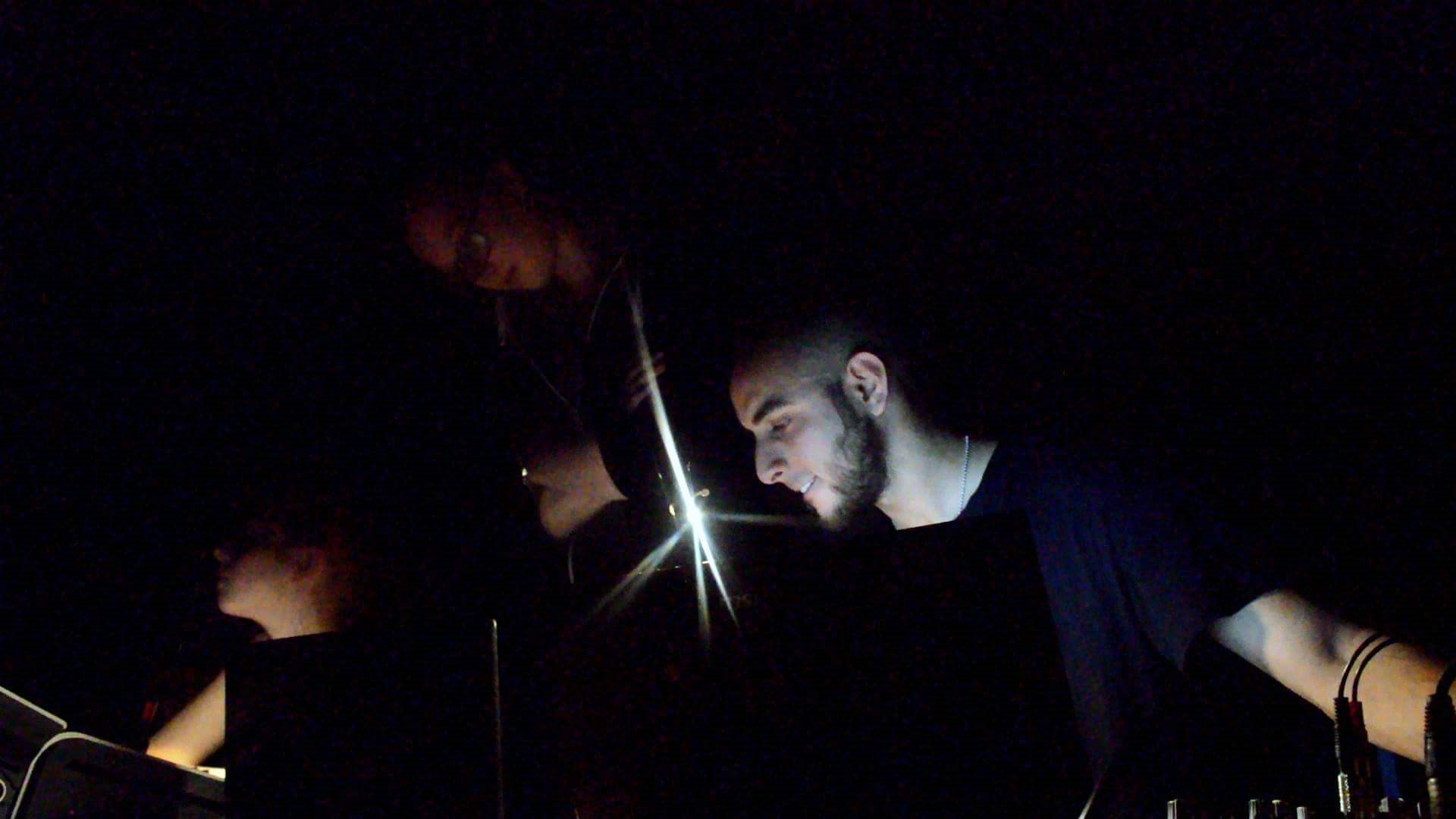 Wahid at work in a dark studio, lit by a single light